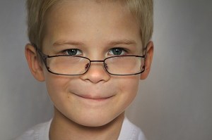 a boy wearing glasses and smiling